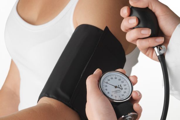 a doctor taking blood pressure of a patient